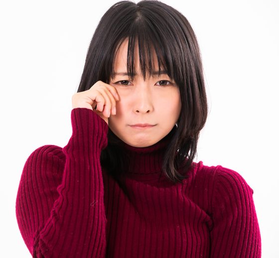 目もとをぬぐう女性